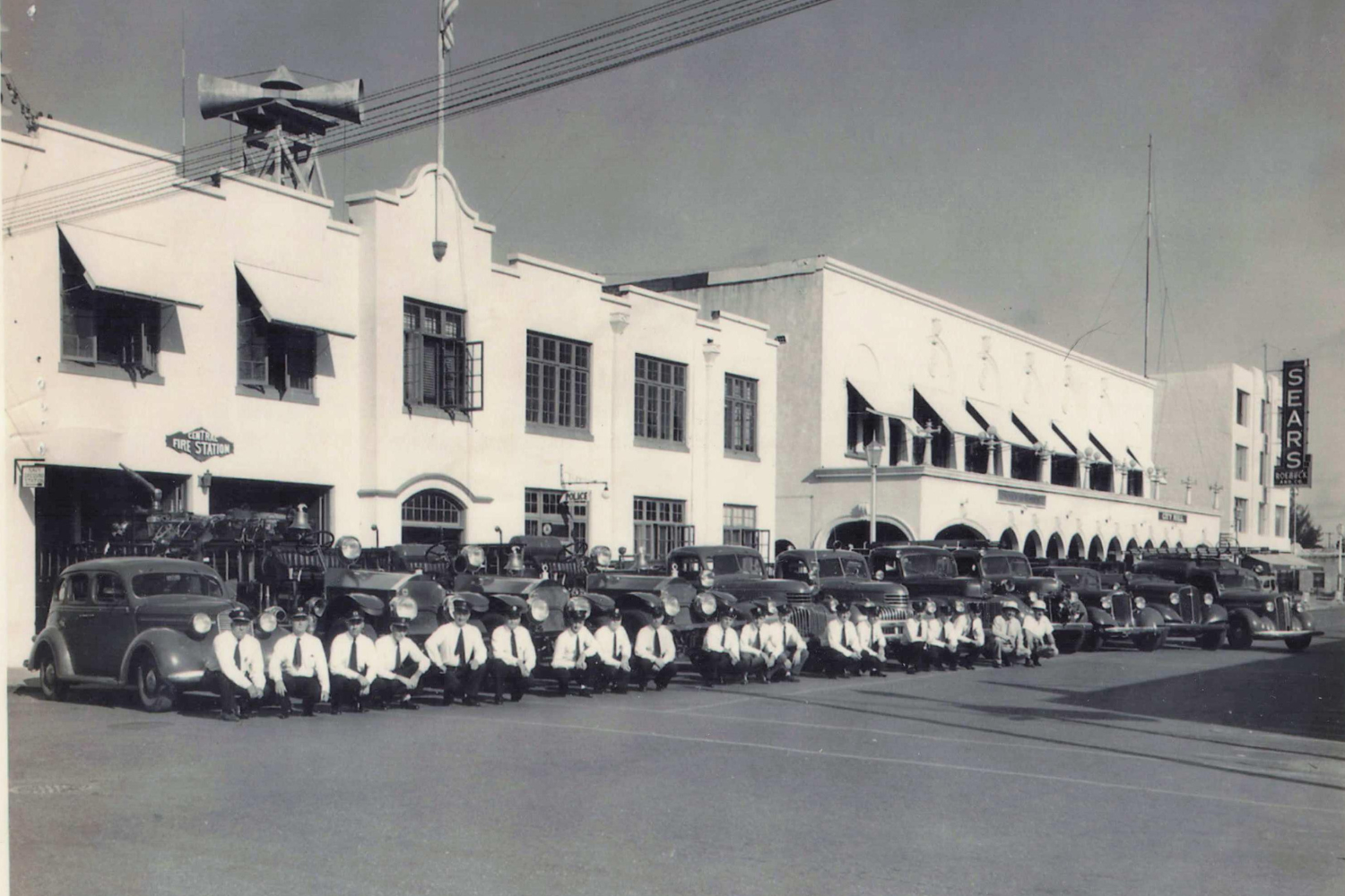 fire-museum-history-exhibit-fort-lauderdale 1930s photograph of Fort Lauderdale’s Central Fire Station with firefighters and vintage fire engines lined up along South Andrews Avenue.