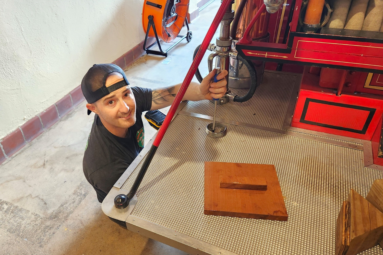 Volunteer restoring a vintage fire engine inside the Fort Lauderdale Fire and Safety Museum.