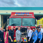 Fort Lauderdale Fire Rescue team and city officials standing in front of new Hazmat and ARFF fire trucks during fire truck push-in ceremony.